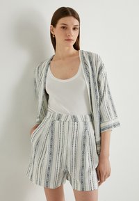 Letvægts, stribet kimono-lignende jakke med blå og hvide mønstre, der er parret med matchende mønstrede shorts. Har en afslappet pasform og lommer.
