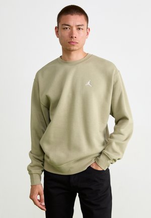 Olivengrøn sweatshirt med rund hals og ribstrik ved ærmerne, der har et lille hvidt Jordan-logo på brystet. Bæres med sorte bukser.