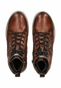 Botas de tobillo de cuero marrón con cordones negros, acabado texturizado y un cuello acolchado. Cuentan con un cierre lateral y una suela blanca contrastante.