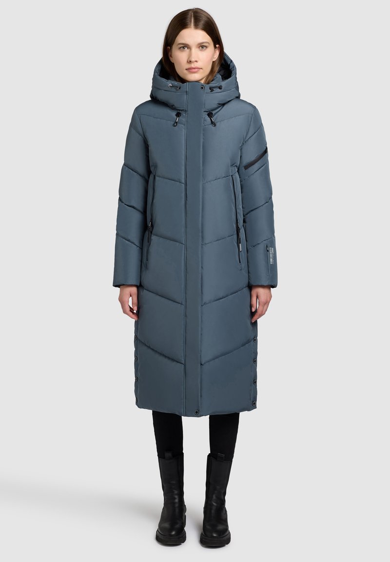 Gevoerde lange jas in blauw-grijs, met een ritsluiting, grote capuchon, rits- en knoopaccenten en verticale stikpatronen.