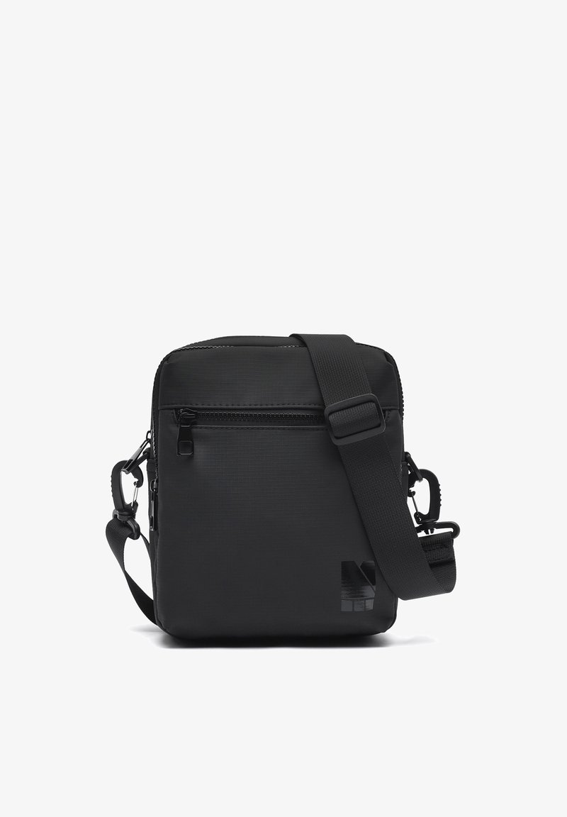 Bolso bandolera rectangular negro con correa ajustable, bolsillo frontal con cremallera y logo sutil en la esquina inferior derecha.