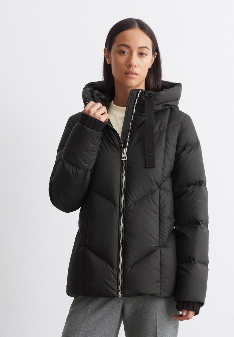 Giubbotto imbottito nero con zip frontale, cappuccio grande e polsini a coste, caratterizzato da un motivo geometrico a trapunta e una texture morbida.