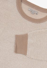 Jersey de punto beige con un patrón texturizado, escote redondo y un bolsillo en tono marrón claro con bordes acanalados. La etiqueta dice "DAN JOHN", tamaño M.