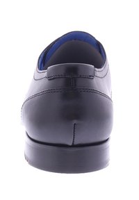 Schwarze Lederschuhe, glatte Oberfläche, leicht abgerundete Spitze, gestickte Akzente, blaue Fütterung sichtbar am Eingang, stabiler Absatz.