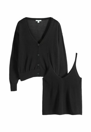 Fekete kötött kardigán gombokkal, és hozzáillő, ujjatlan, V-nyakú felső vékony pántokkal, mindkettő laposan fektetve fehér háttéren.