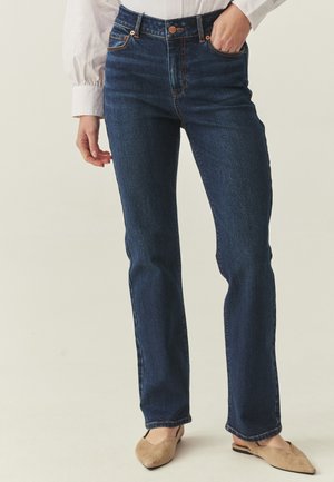 Mørkeblå højtaljede jeans med lige ben. Detaljer inkluderer orange syninger, fem-lomme stil og metalhardware-accenter.