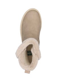 Beige Wildleder-Stiefelette mit einem weichen, hellen Kunstfellfutter. Runde Zehenform, genähte Details an der Sohle und eine Schlaufe an der Ferse.