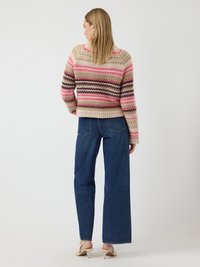 Sweater a maglia con strisce rosa, beige e marroni; aderente in vita, maniche lunghe. Abbinato a jeans a gamba larga blu a vita alta e tacchi leggeri.