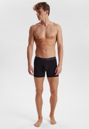 Schwarze Baumwoll-Boxershorts mit enganliegender Passform und einem elastischen Bund, der den Markennamen "DOVRE" in einem dezenten grauen Schriftzug trägt.