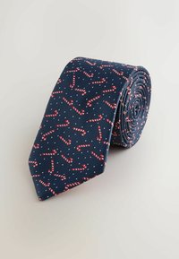 Sötétkék nyakkendő, vörös és fehér cukorpálca mintával, apró fehér pöttyökkel egy texturált háttéren. Kiállításhoz feltekerve.