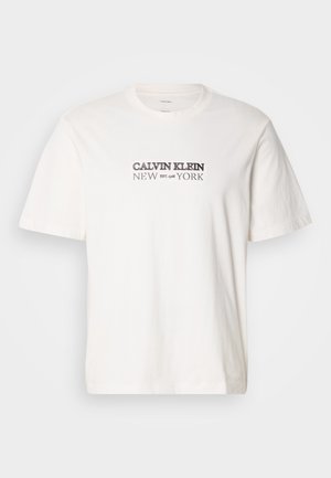 Biała bawełniana koszulka z krótkimi rękawami, okrągłym dekoltem i nadrukiem "CALVIN KLEIN NEW YORK" w ciemnoszarym kolorze na piersi.