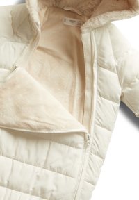 Padded cream-colored jacket with a soft beige fur lining, featuring a zip closure and quilted exterior design.