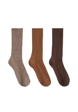 Trois paires de chaussettes mi-mollet dans différentes nuances de brun : clair texturé, moyen côtelé et foncé côtelé, disposées côte à côte sur fond blanc.