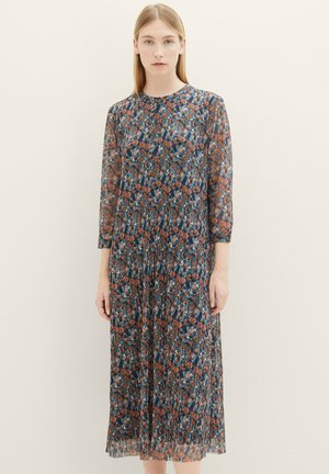 Blumenkleid in Midi-Länge aus transparentem, plissiertem Stoff mit einem dunkelblauen Grundton und orangefarbenen sowie türkisfarbenen Mustern. Rundhalsausschnitt und dreiviertellange Ärmel.