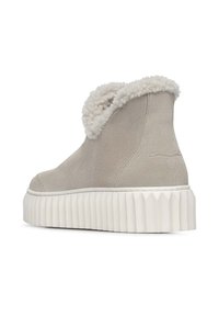 Grijze Suède enkellaars met een pluizige witte schapenwollen kraag, voorzien van een dikke witte ribbelsol en minimalistische ontwerpelementen.