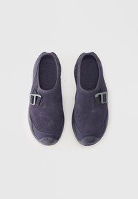 Σκούρα μπλε σουέντ παπούτσια τύπου slip-on με υφή στο άνω μέρος, στρογγυλεμένη μύτη και γκρι πόρπη ως διακοσμητικό. Λαστιχένια σόλα για καλύτερη πρόσφυση και άνεση.