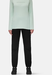 Licht mintgroene longsleeve shirt met "Mammut" logo, gecombineerd met zwarte broek met elastische boorden, ontworpen voor buitenactiviteiten.