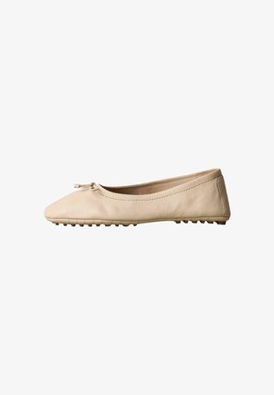 Chaussure ballerine beige avec bout arrondi, petit détail de nœud et semelle texturée pour l'adhérence, vue de côté sur fond blanc.