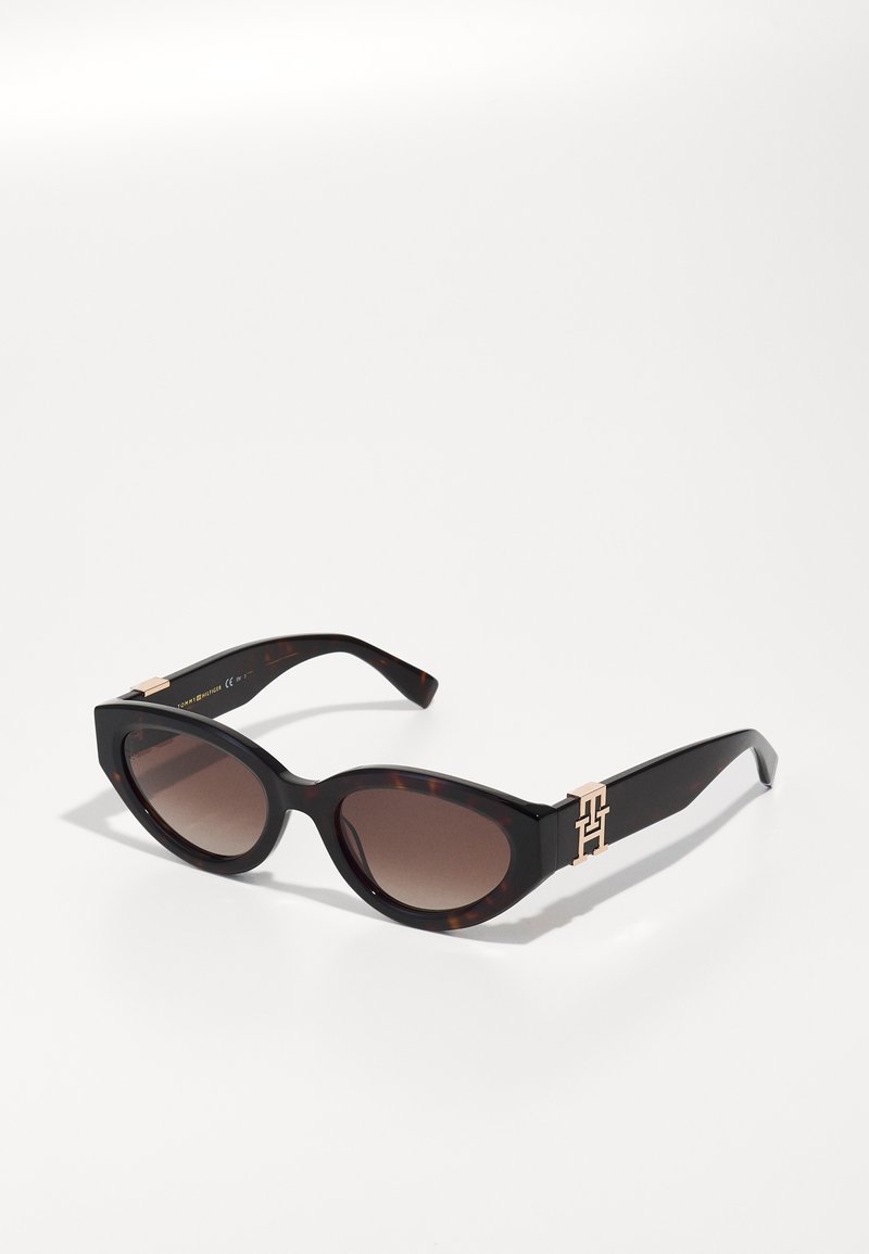 Cat-eye sunglasses with brown gradient lenses, tortoiseshell frame, and gold-tone logo accent on temples. Smooth plastic material.
