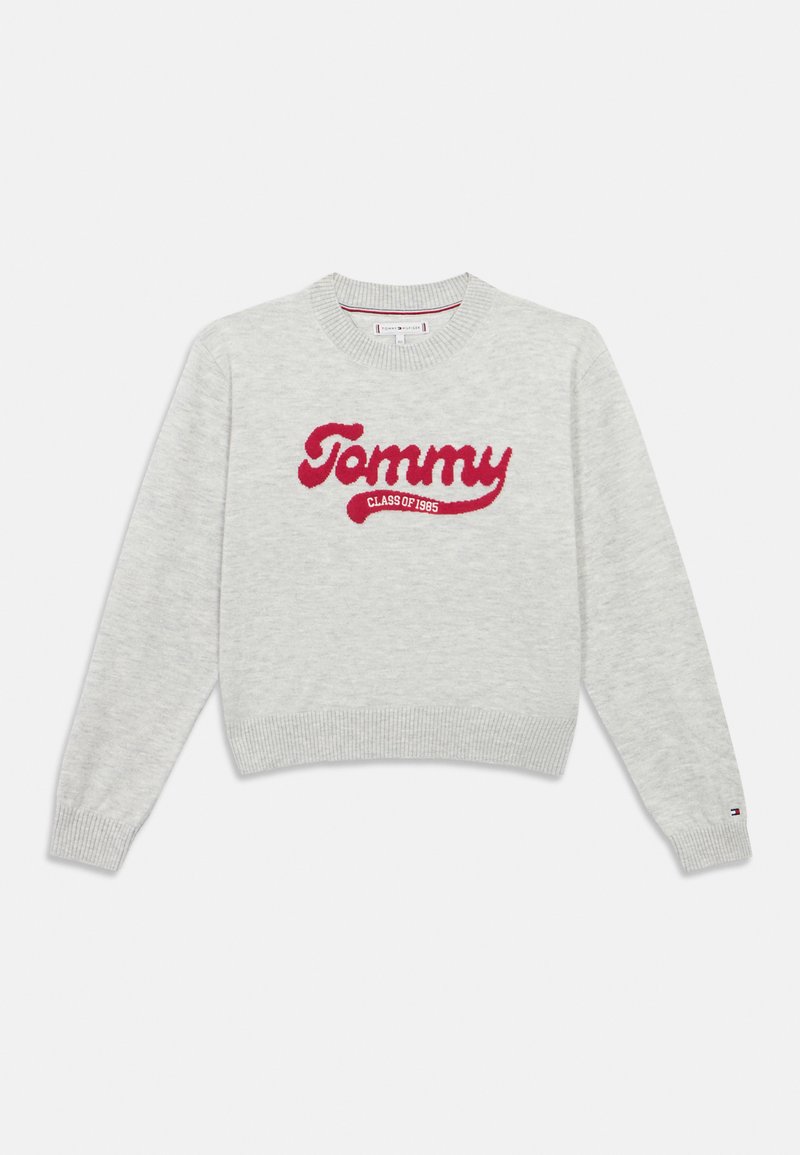 Gaišpelēka adīta džemperis ar sarkano „Tommy Class of 1985” tekstu priekšpusē un mazo Tommy Hilfiger logo kreisajā piedūrē.