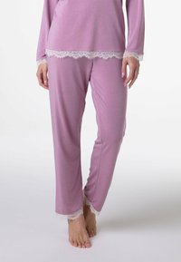 Completo con top a maniche lunghe di un morbido lilla e pantaloni abbinati, caratterizzato da un merletto bianco sui polsini e sull'orlo. I pantaloni presentano un design a gamba dritta.