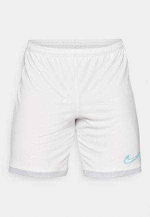 Pantalones cortos deportivos blancos con cintura elástica, ribete de malla y un logo de swoosh de Nike en color turquesa en la parte inferior derecha.