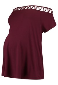 Burgundyröd graviditetstopp med korta ärmar, av-axeln design och utskärningsdetaljer vid halsringningen, tillverkad av mjukt tyg.