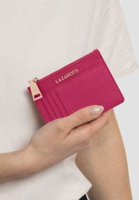 Portafogli in pelle testurizzata rosa con più scomparti per carte, chiusura con zip e dettagli in metallo dorato. Nome del marchio "LAZAROTTI" impresso sulla parte anteriore.
