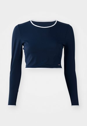 Marineblaues Langarm-Crop-Top aus glattem Stoff, mit einem weißen Rundhalsausschnitt und kontrastierenden weißen Akzenten an den Ärmeln.