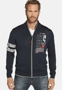 Marineblauer gestrickter Reißverschluss-Pullover aus strukturiertem Stoff, mit gerippten Bündchen und grauen Akzenten. Merkmale grafische Drucke und ein hoch geschnittenes Design.