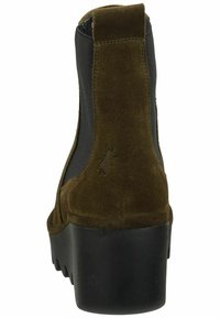 Stivale alla caviglia in suede marrone con un lato elastico nero testurizzato, punta tonda e una suola piatta nera spessa, dotato di un sottile dettaglio del logo.