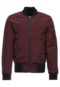 Chaqueta bomber burdeos con cremallera frontal, puños y dobladillo de canalé negros, y un bolsillo con cremallera en la manga izquierda. Tejido suave y brillante.
