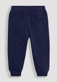 Navy cotton jogger pants with a soft texture, featuring elastic waistband, cuffed ankles, and two back pockets.