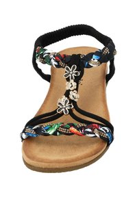 Czarne sandały z kolorowymi plecionymi paskami, kwiatowymi akcentami i wyściółką w kolorze brązowym. Posiadają elastyczny pasek dla wygody.