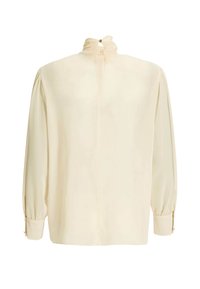 Blouse crème avec manches longues bouffantes, col montant froncé et fermeture boutonnée dans le dos.