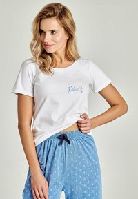 Biała bawełniana koszulka z napisem „Relax” i nadrukiem kotwicy; zestawiona z jasnoniebieskimi spodniami do piżamy z wzorem kotwic i ściągaczem w talii.