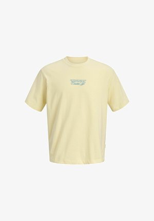 Bladożółta koszulka z krótkim rękawem z niebieskim napisem na piersi: „LES VOYAGES TAKE US TO THE SUN AND THE SEA, Coastal Life.”