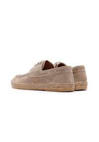 Zapatos de ante beige con un diseño de cordones, que cuentan con una suela envuelta en yute y ojales plateados para los cordones, con un acabado texturizado.