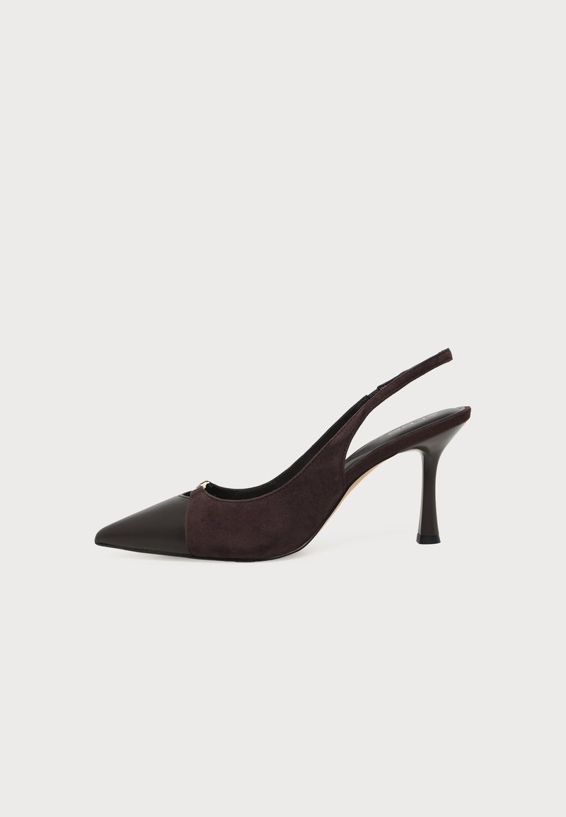 Chaussure à talon haut slingback en cuir et daim noir et marron foncé, avec un bout pointu et un talon aiguille fin sur fond blanc.