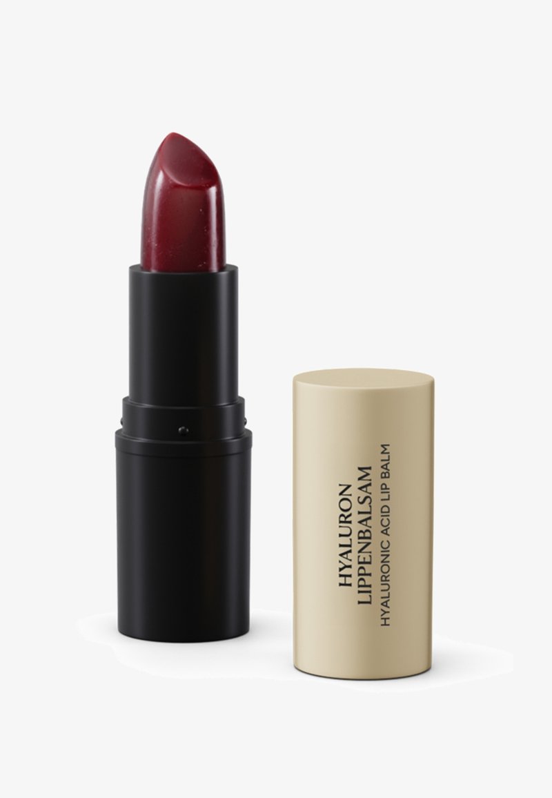 Dark red lipstick with black base next to beige cap labeled "Hyaluron Lippenbalsam Hyaluronic Acid Lip Balm" on white background.