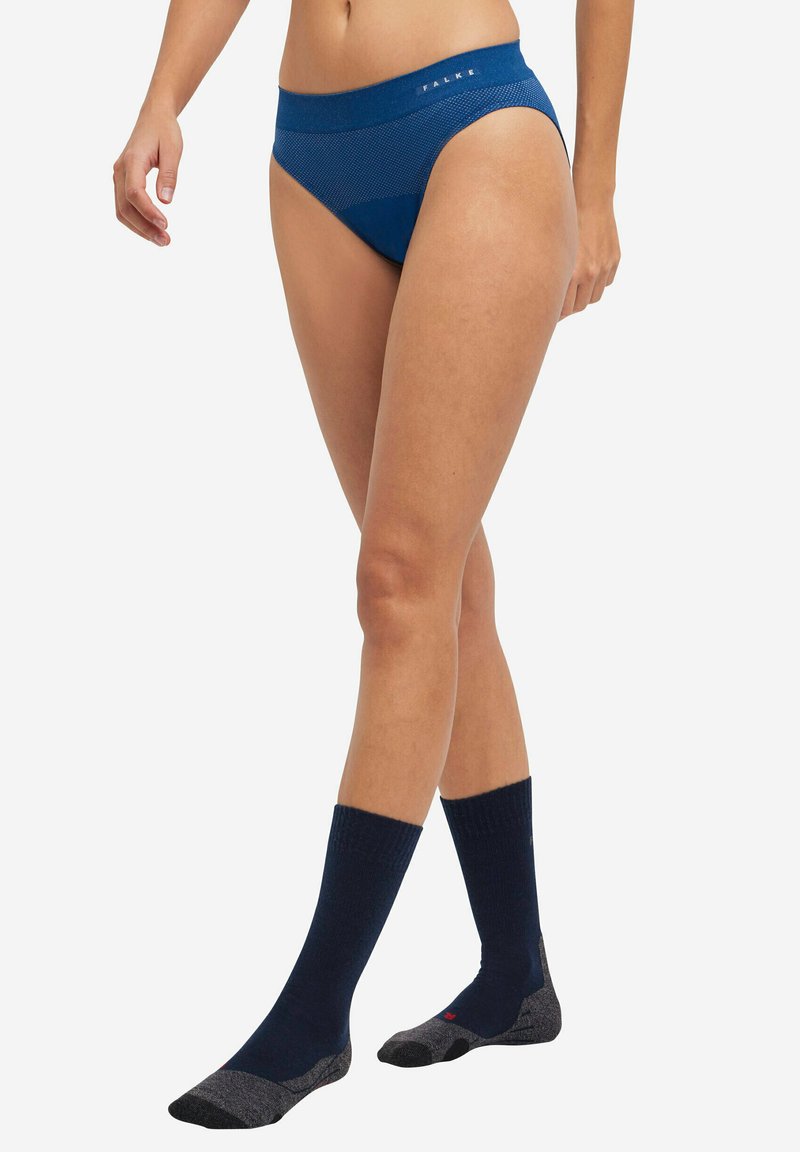 Mutande blu navy con un design testurizzato, dotate di un ampio elastico in vita. Indossate con calze blu navy alte fino al ginocchio, che mostrano accenti grigio a contrasto.