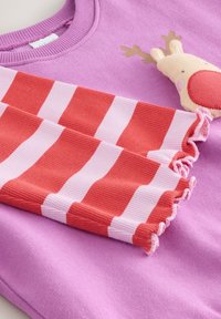 Fliederfarbener Pullover mit Rentier-Applikation, kombiniert mit gerippten Ärmeln in abwechselnden rot- und pinkgestreiften Mustern und mit Rüschen an den Kanten.