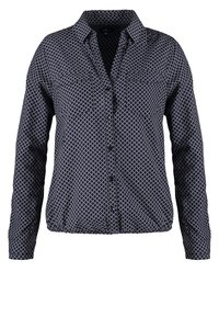 Chemise bleu marine à manches longues avec motif en treillis blanc, boutonnage devant, deux poches poitrine et ourlet élastique.