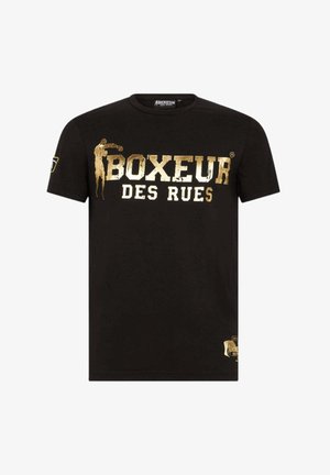 T-shirt in cotone nero con scritta dorata "BOXEUR DES RUES" e una silhouette di pugile, con un'etichetta decorativa sul lato inferiore.