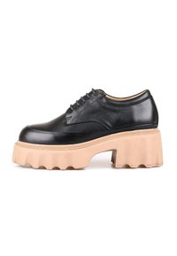 Chaussure en cuir noir avec un bout arrondi et une semelle en caoutchouc beige épaisse à bord ondulé. Design à lacets avec six œillets.