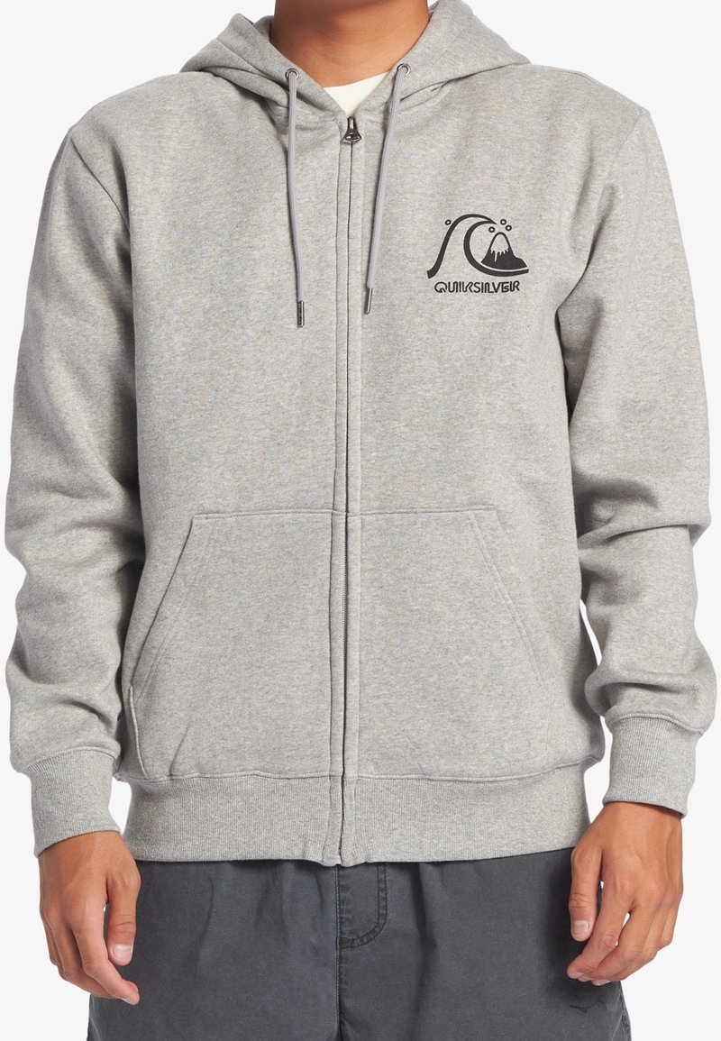 Sudadera gris con cremallera hecha de un tejido suave, con un logo en el lado izquierdo del pecho, bolsillos frontales y capucha ajustable con cordón. Presenta puños y dobladillo acanalados.