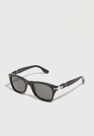 Gafas de sol rectangulares negras con lentes oscuras y detalles decorativos plateados en las patillas, mostradas sobre un fondo blanco.