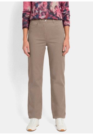 Vue de face d'une personne portant un pantalon beige à coupe droite, des baskets blanches et un haut à manches longues multicolore rose et violet à motifs.