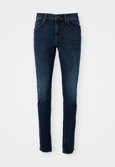 Temno modri kavbojke z vitkim krojem, strukturirano zasnovo, petimi žepe, ter svetlimi madeži obrabe vzdolž nog in šivov.