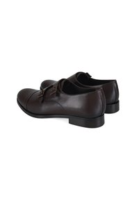 Bruine leren schoenen met een gestroomlijnd ontwerp, ronde neus en dubbele gesps. Lage, rechthoekige hak en een gladde textuur.